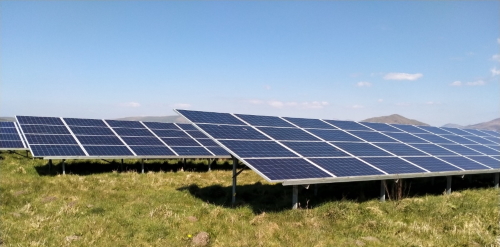 This image: A photo of a solar panel array in a field, on a
					 		 similar scheme to Billown Solar.
							 The map: The map has zoomed in to the site location, between
							 the A7, A3 and A5. The steam railway line is shown passing
							 south of the site. Also to the south is Castletown.